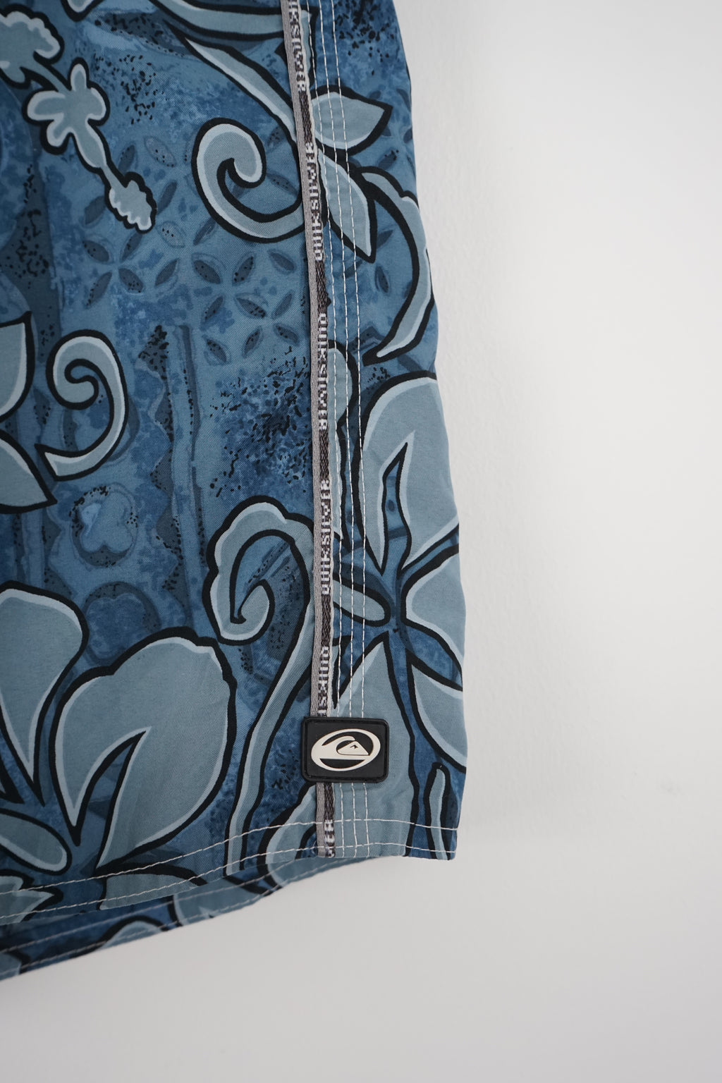 Blue floral-patterned shorts on a white hanger