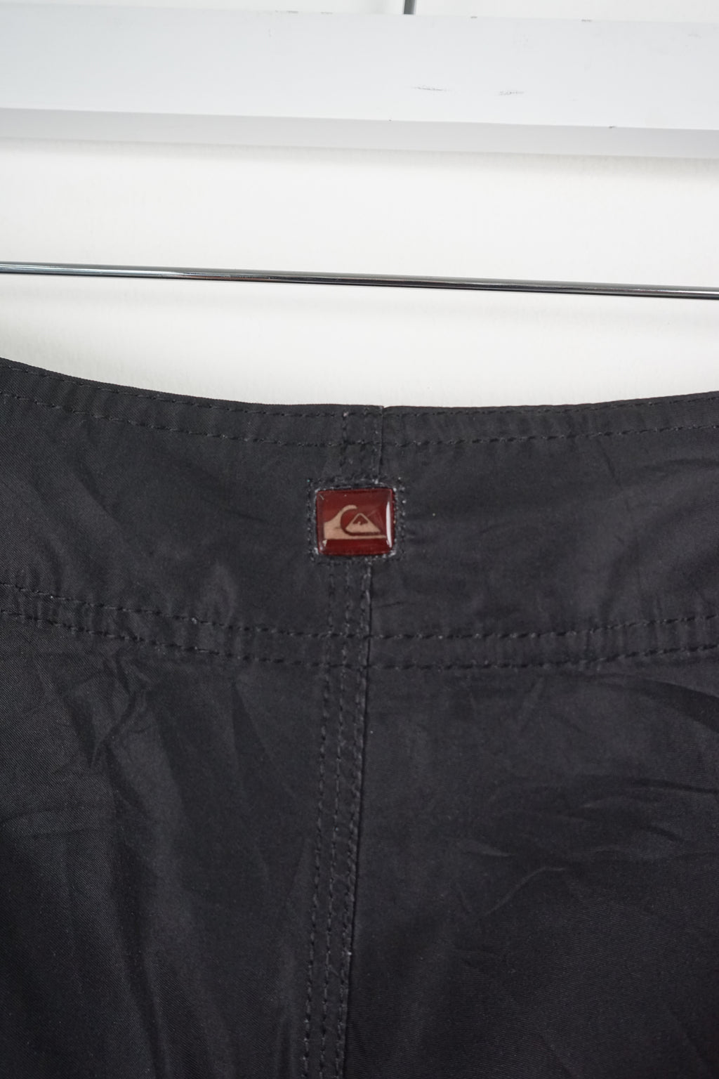 Black and red striped shorts with a logo on a white background