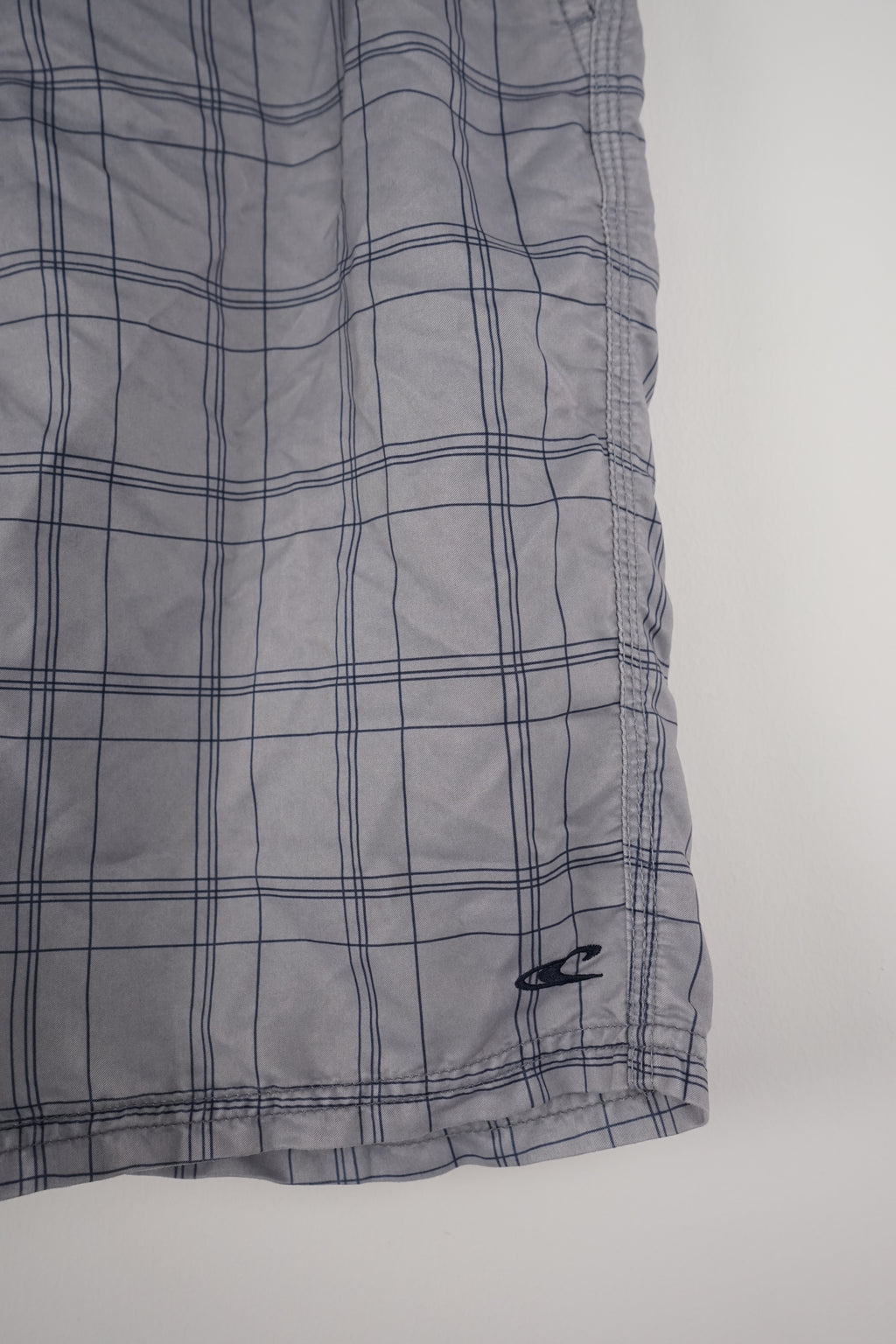 Plaid shorts hanging on a white background