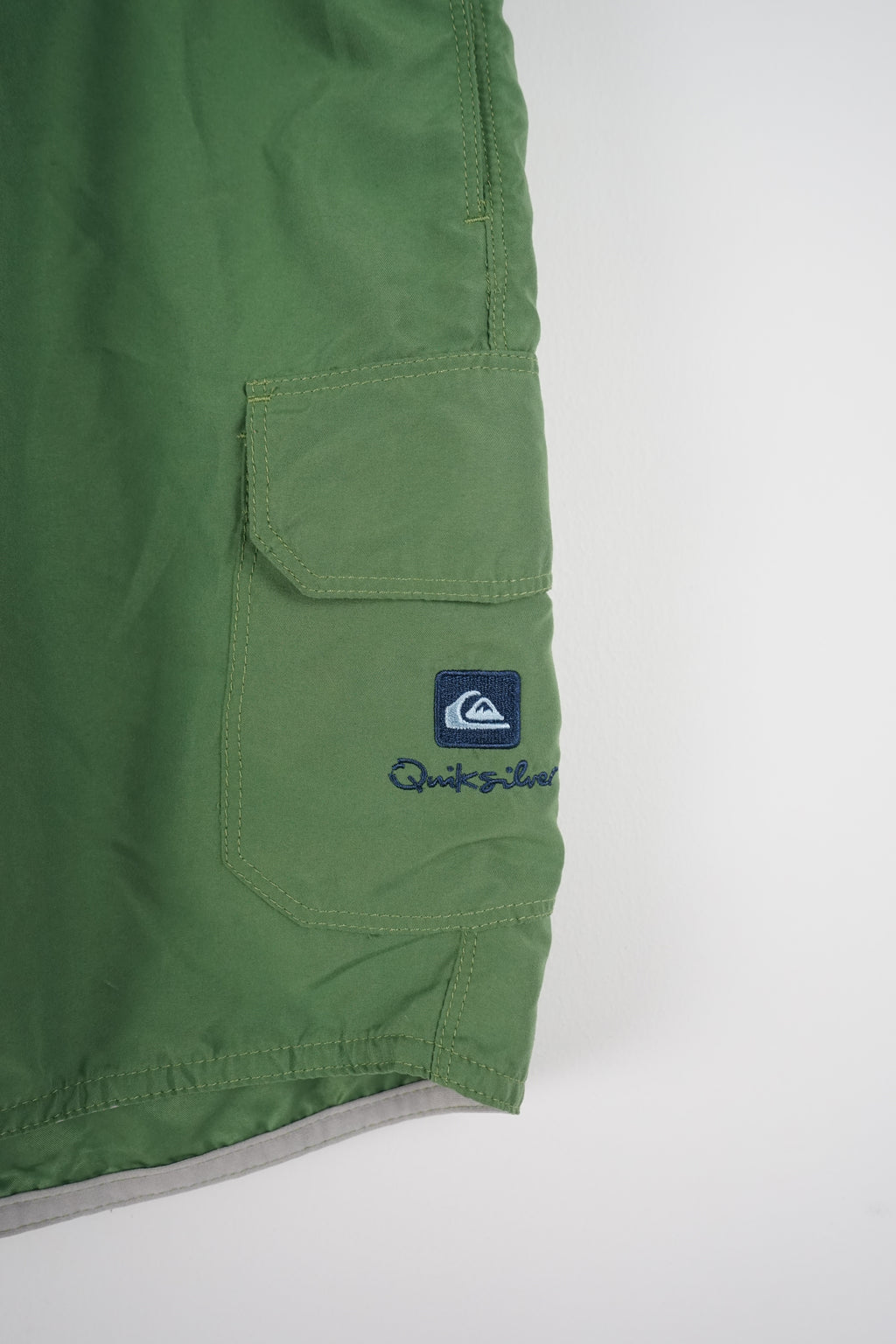 Green shorts with a brand logo on a white background