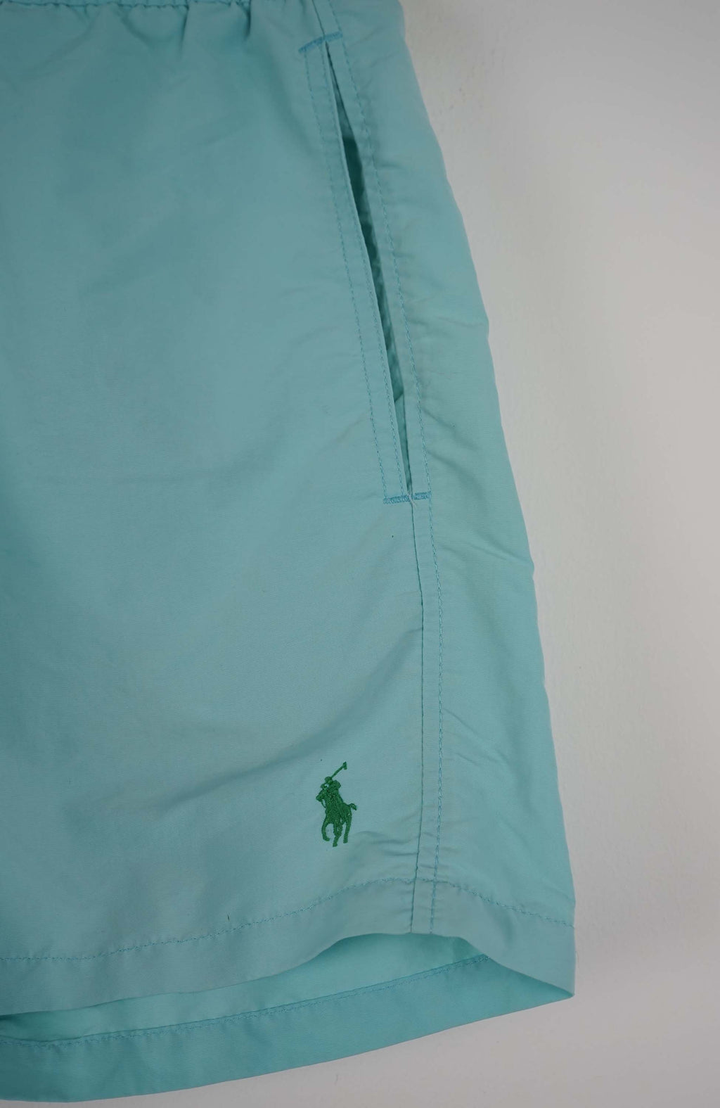 Light blue shorts with a brand logo on a white background