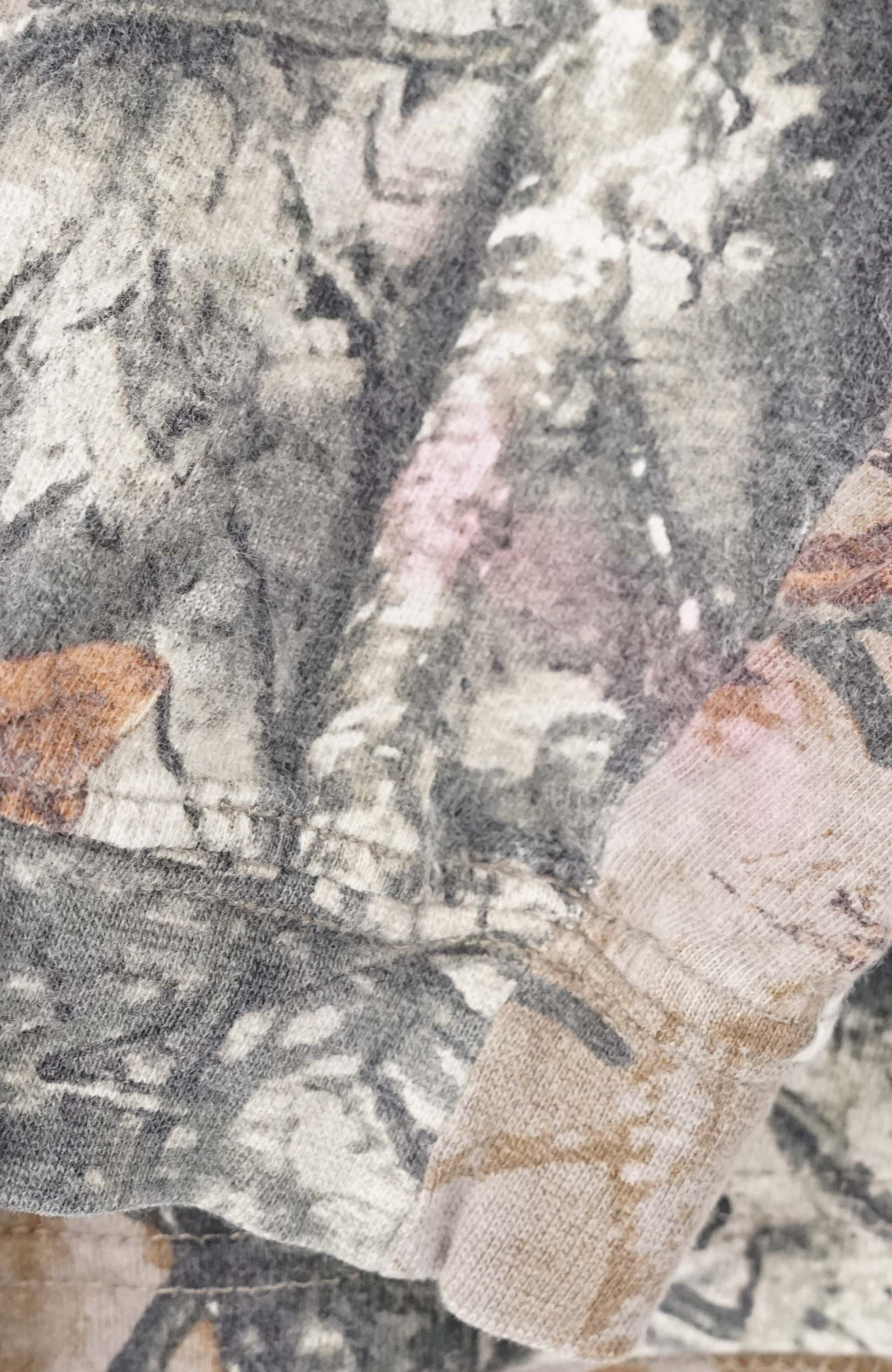 Camouflage-patterned long-sleeve shirt on a white hanger