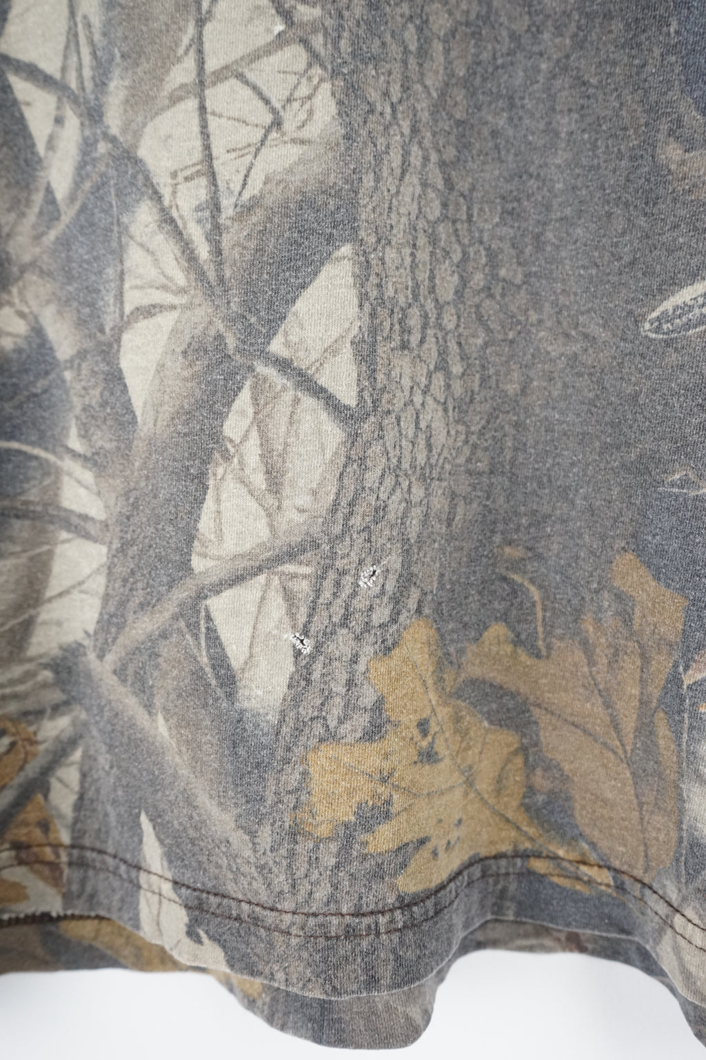 Camouflage-patterned t-shirt with Cabela's branding on a white background
