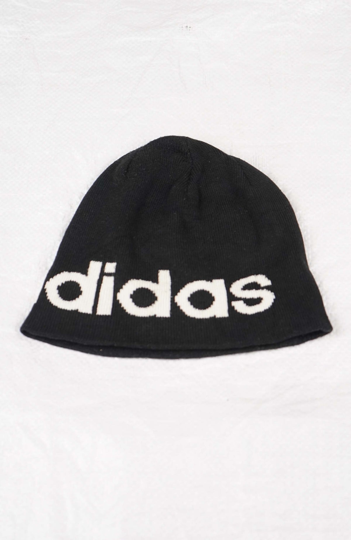 Black beanie with Adidas logo on a white background