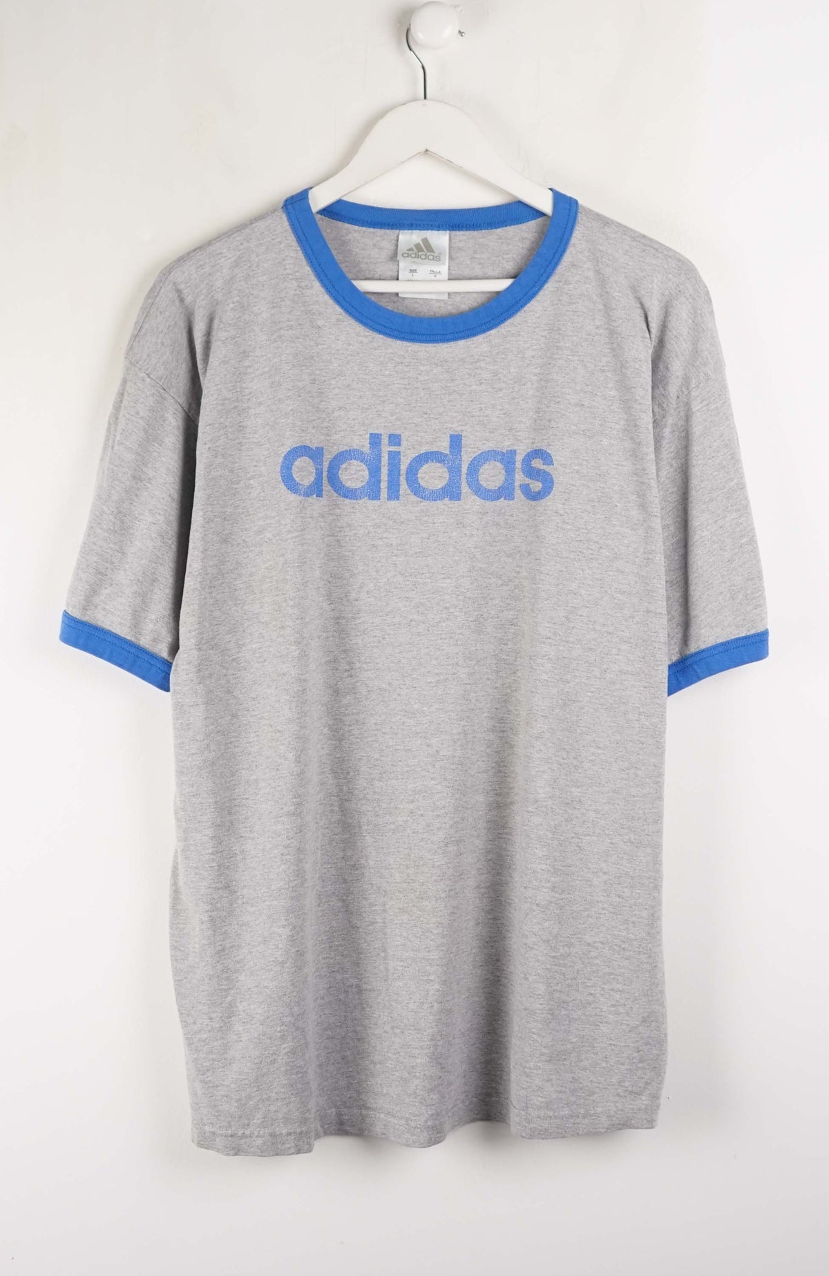 Gray Adidas t-shirt with blue accents on a white hanger