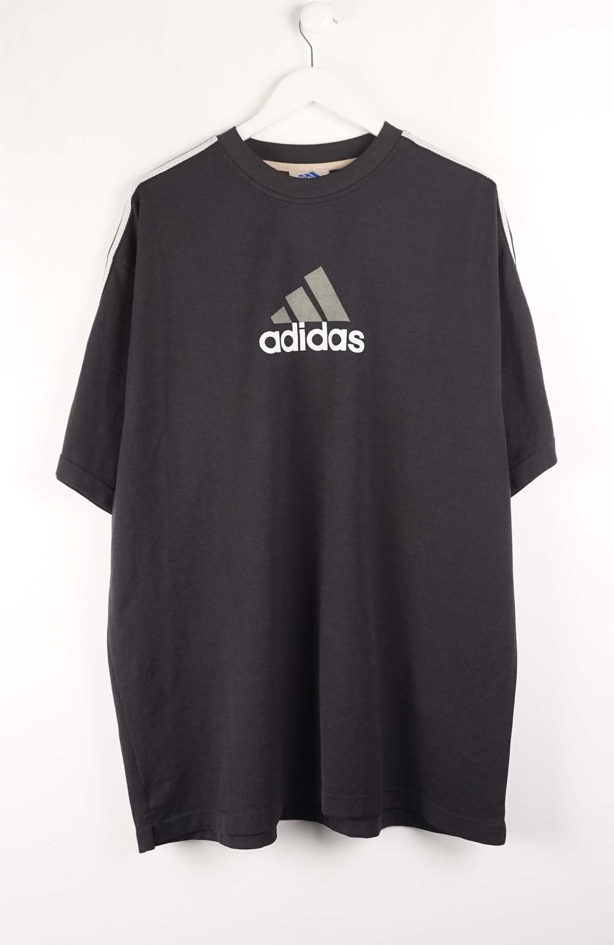 Black Adidas t-shirt on a white hanger against a white background