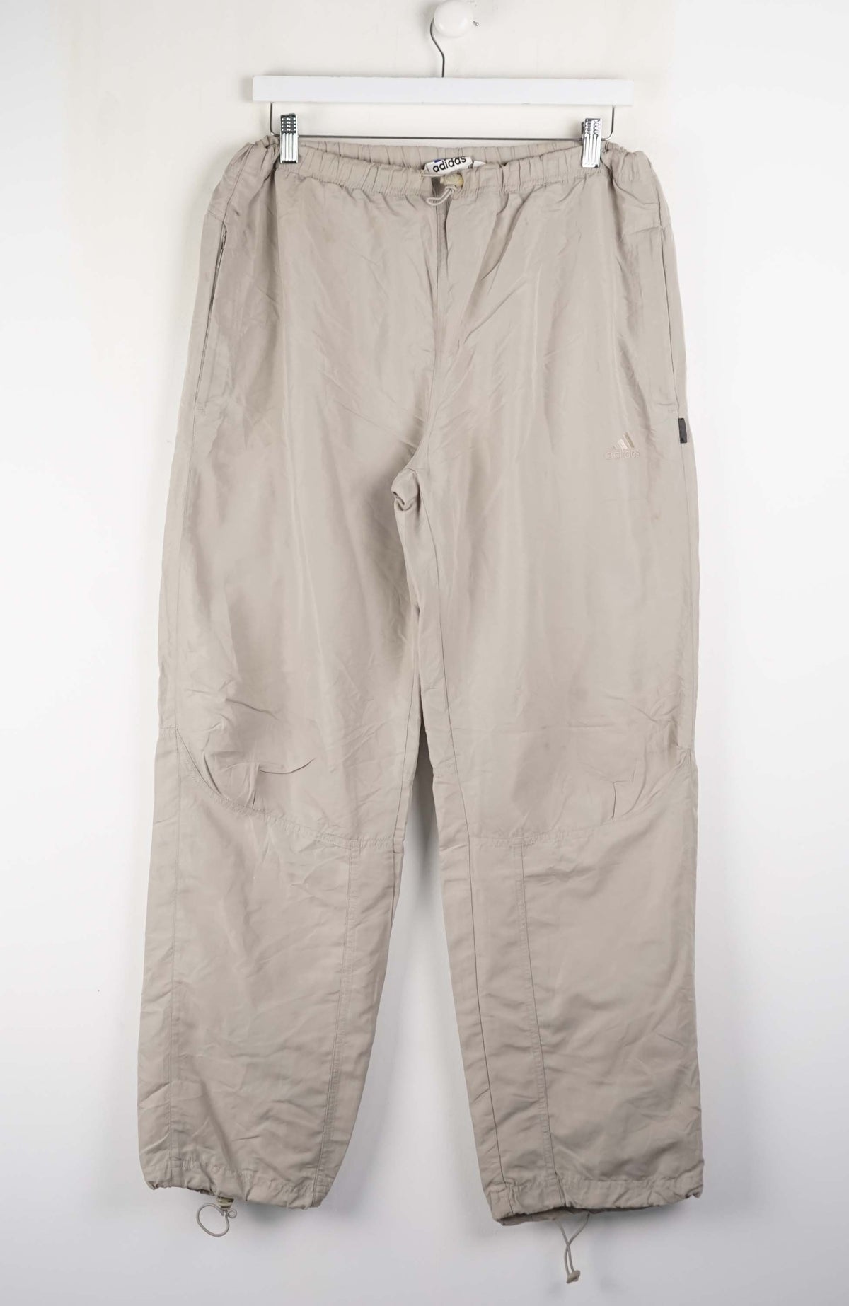 Beige pants hanging on a white wall