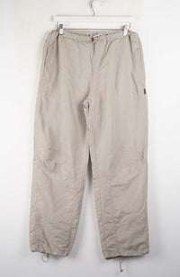 Beige pants hanging on a white wall