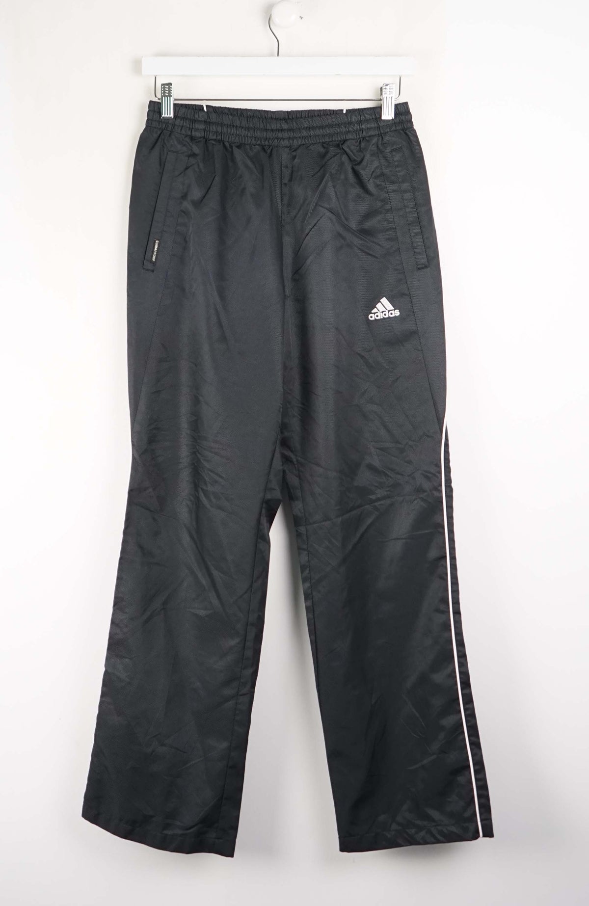 Black Adidas tracksuit pants on a white background