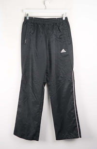 Black Adidas tracksuit pants on a white background