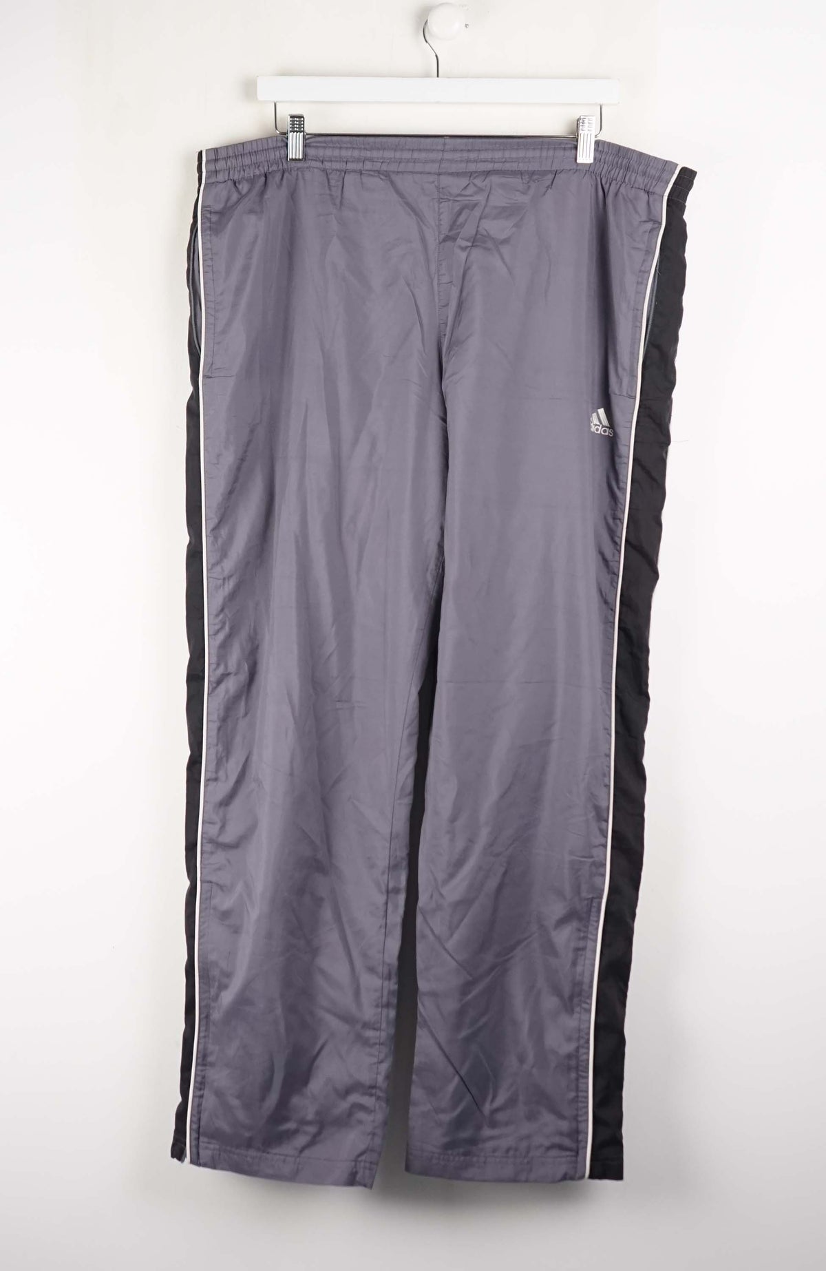 Gray tracksuit pants with black stripes on a white background