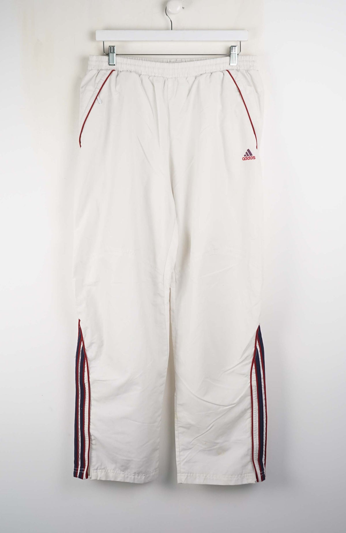 White pants with red and black stripes on a white background