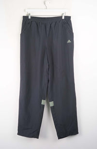 Gray Adidas pants hanging on a white background