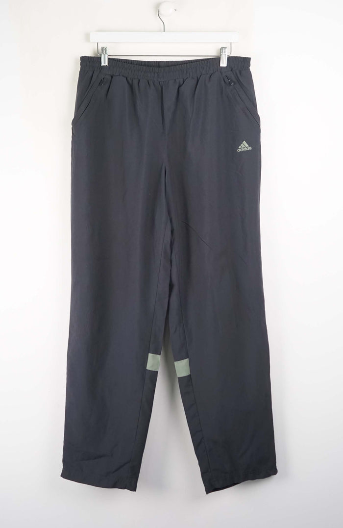 Gray Adidas pants hanging on a white background