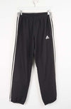 Black Adidas tracksuit pants with white stripes on a white background