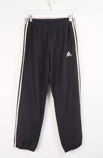Black Adidas tracksuit pants with white stripes on a white background