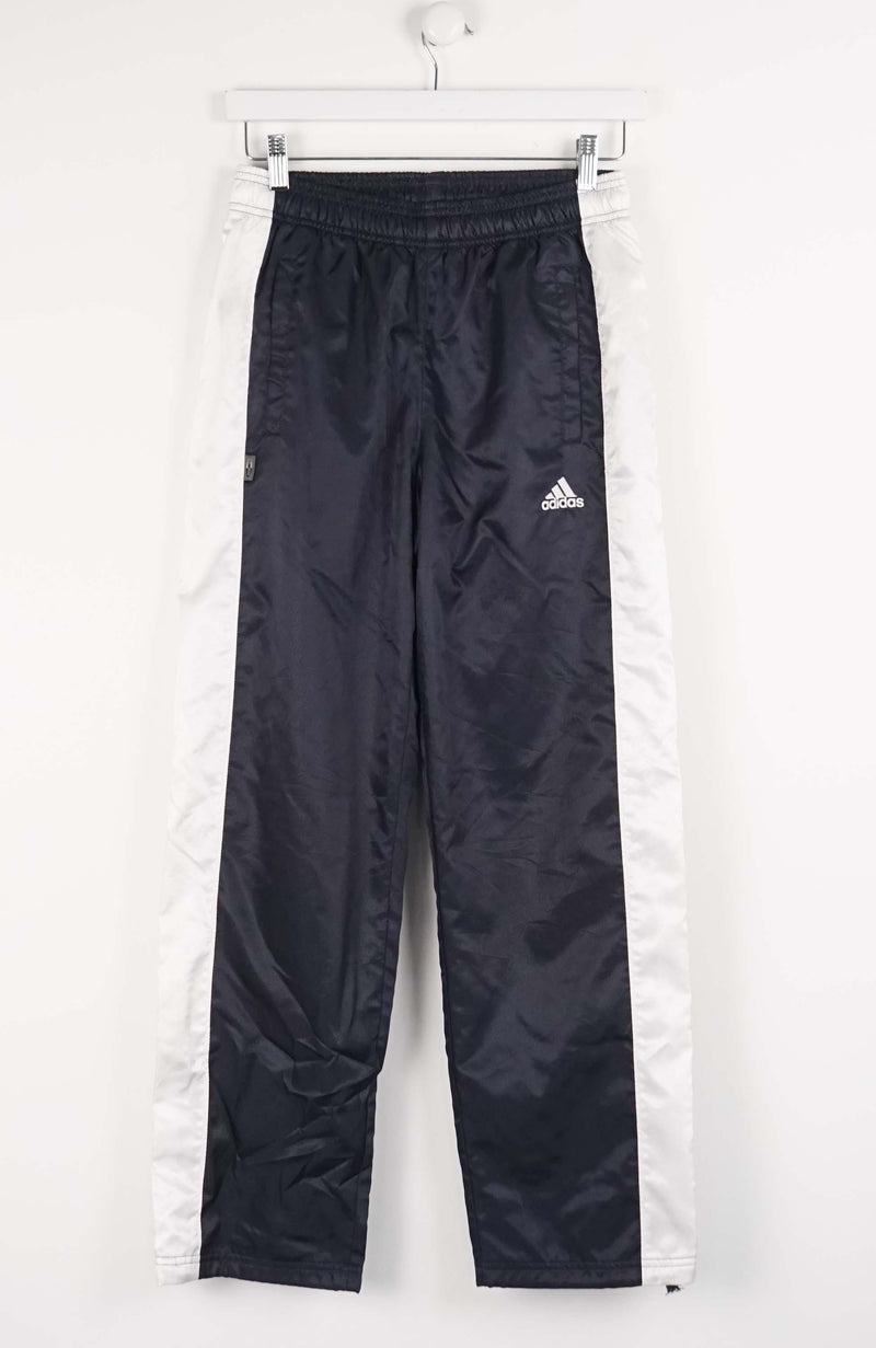 Black Adidas tracksuit pants hanging on a white background