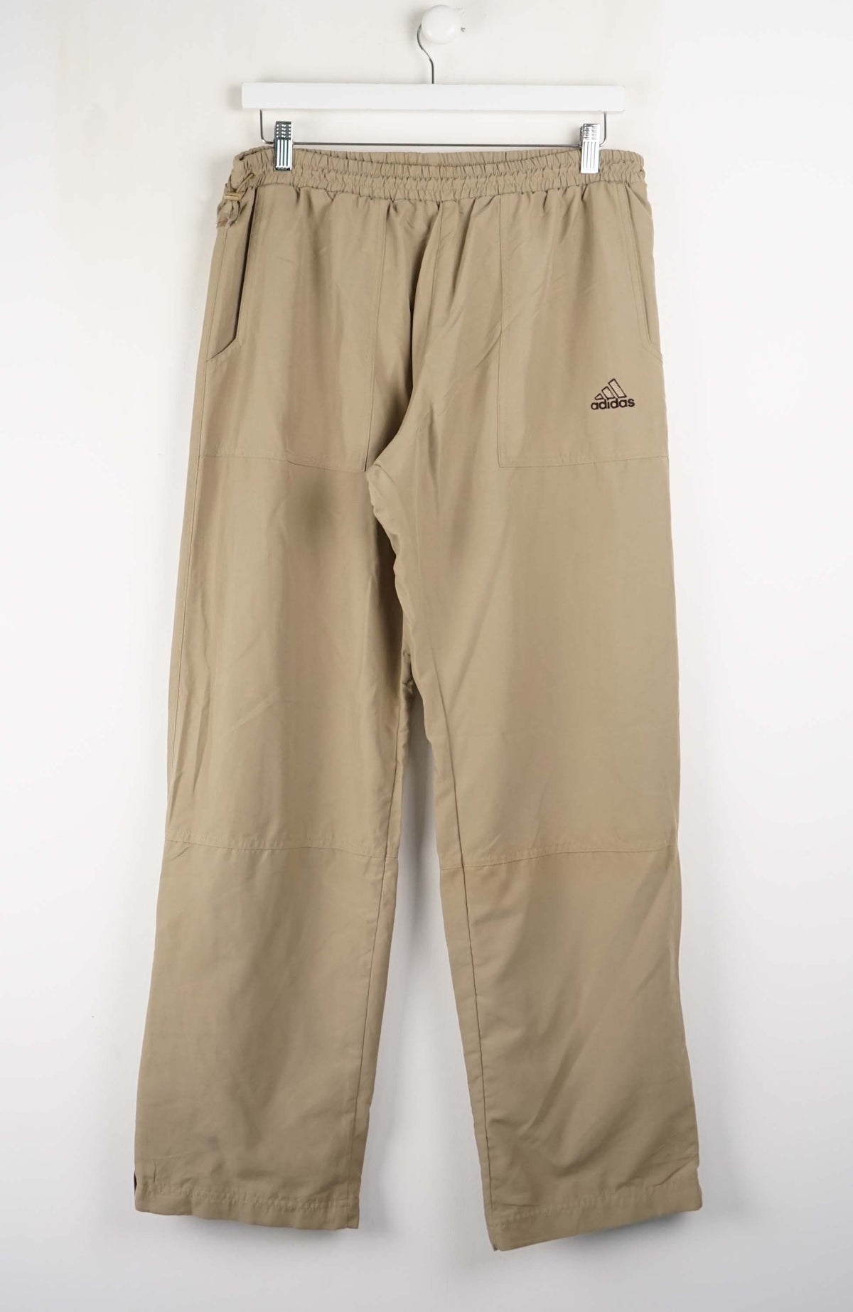 Beige pants with a brand logo on a white background