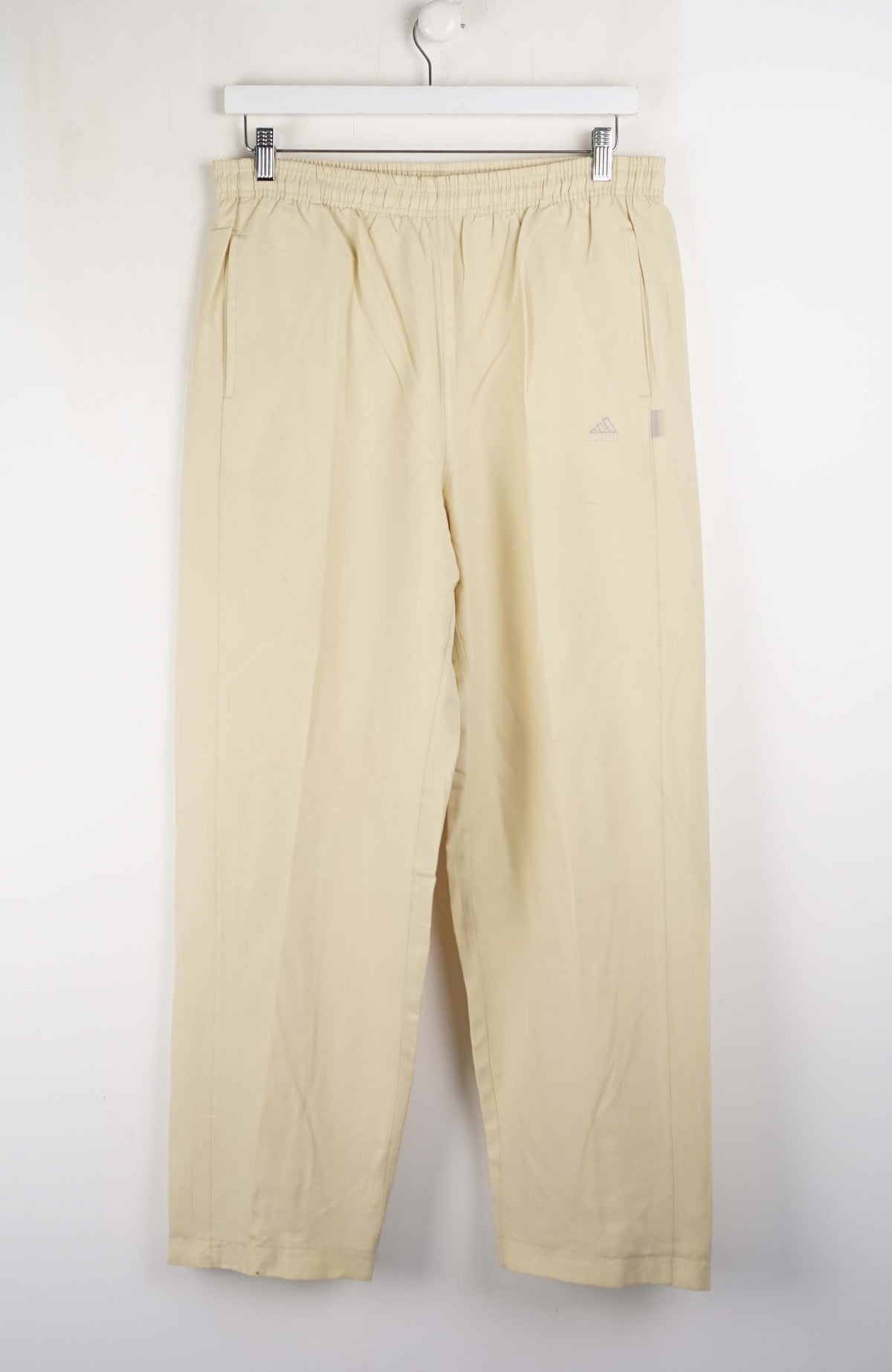 Beige pants hanging on a white background