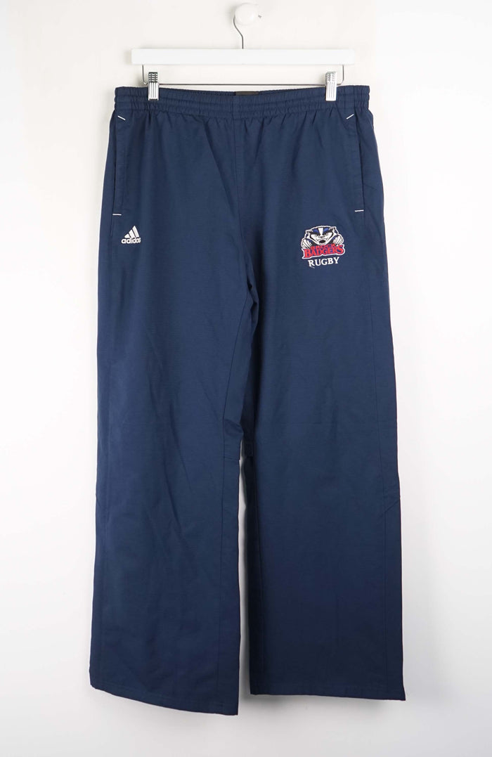 Navy blue rugby pants with a logo and Adidas branding on a white background