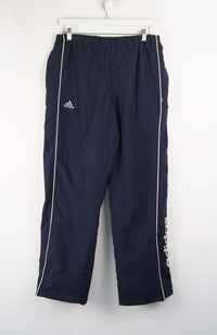 Navy blue Adidas tracksuit pants on a white background