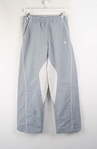 Gray pants with white accents hanging on a white wall