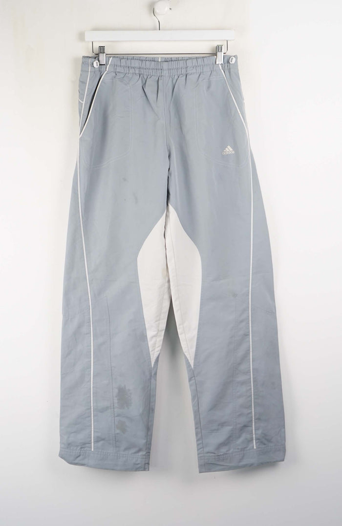 Gray pants with white accents hanging on a white wall