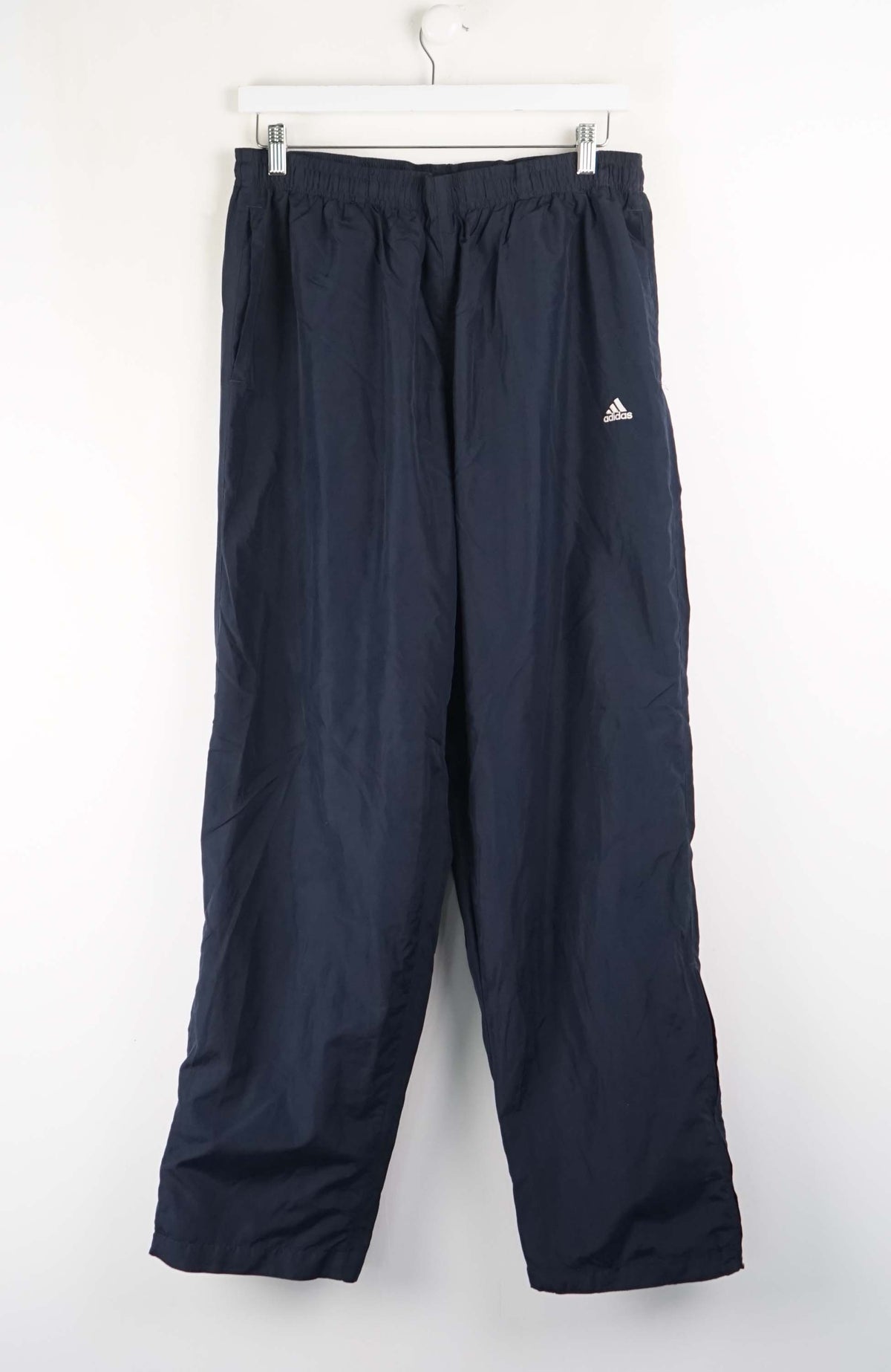 Navy blue pants with Adidas logo on a white background