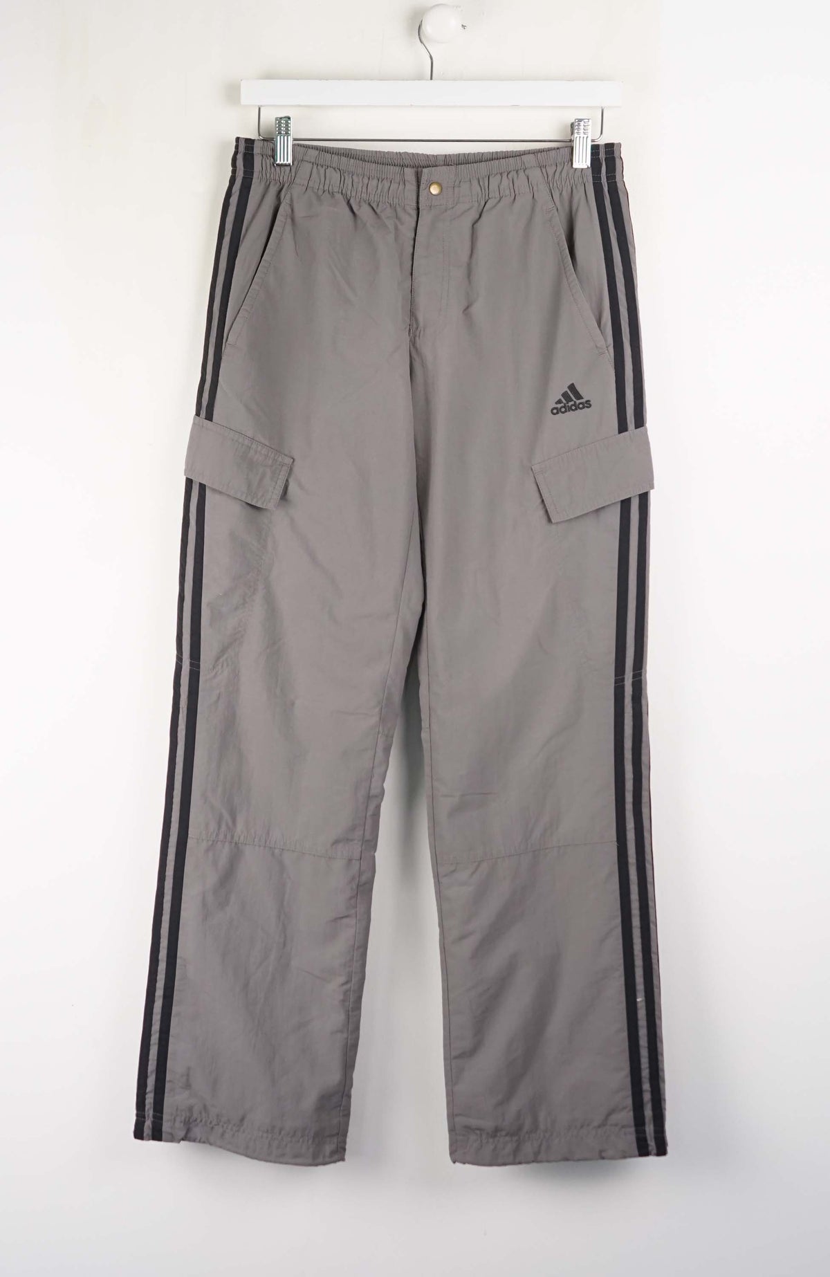 Gray Adidas pants with black stripes on a white background