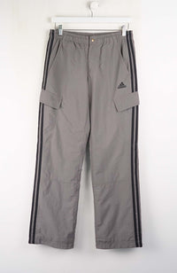 Gray Adidas pants with black stripes on a white background