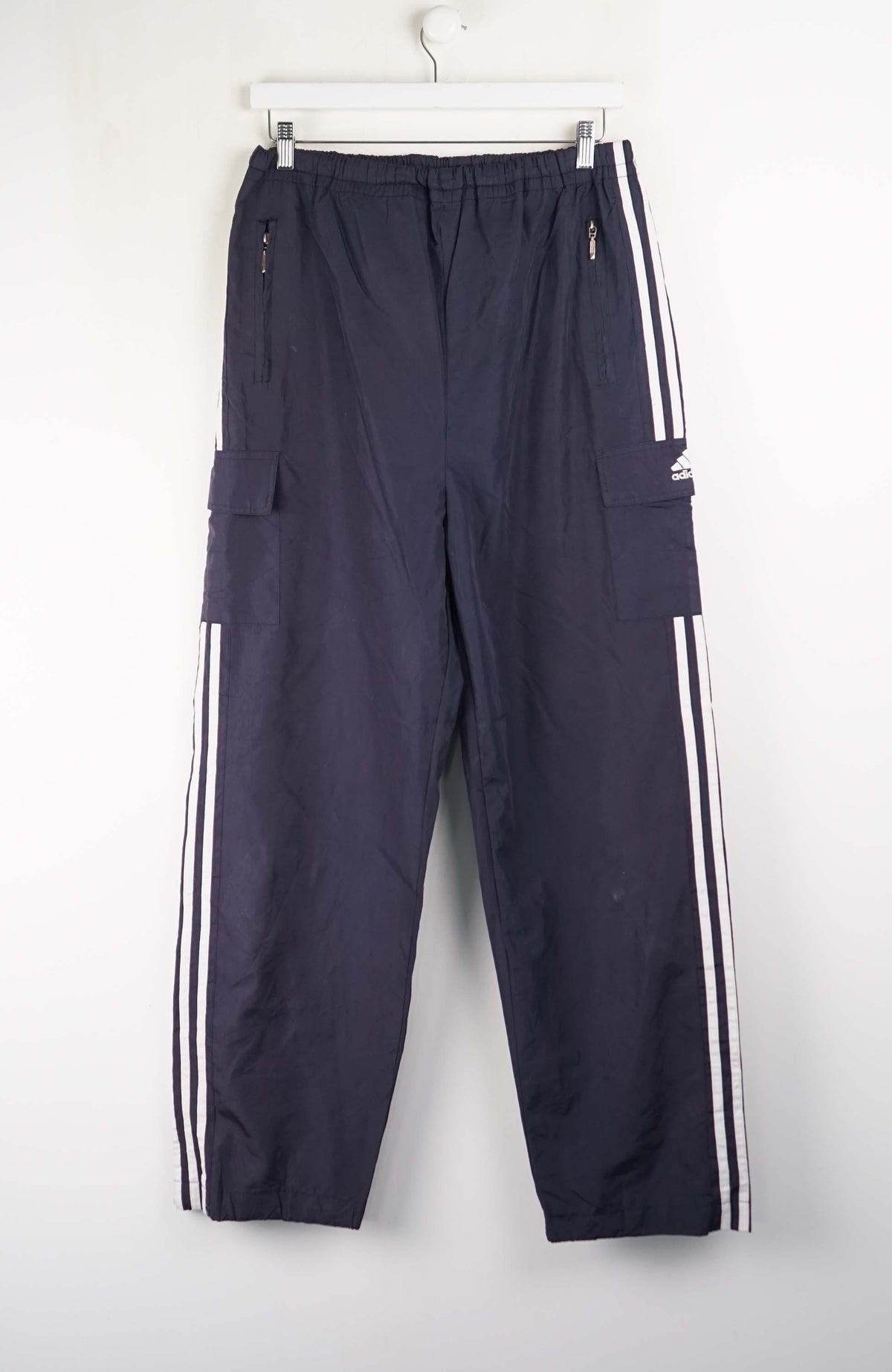 Navy blue pants with white stripes hanging on a white background
