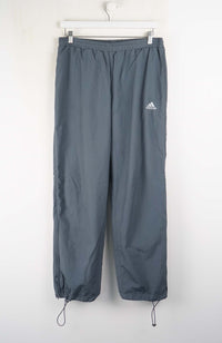 Gray Adidas pants on a white hanger against a white background