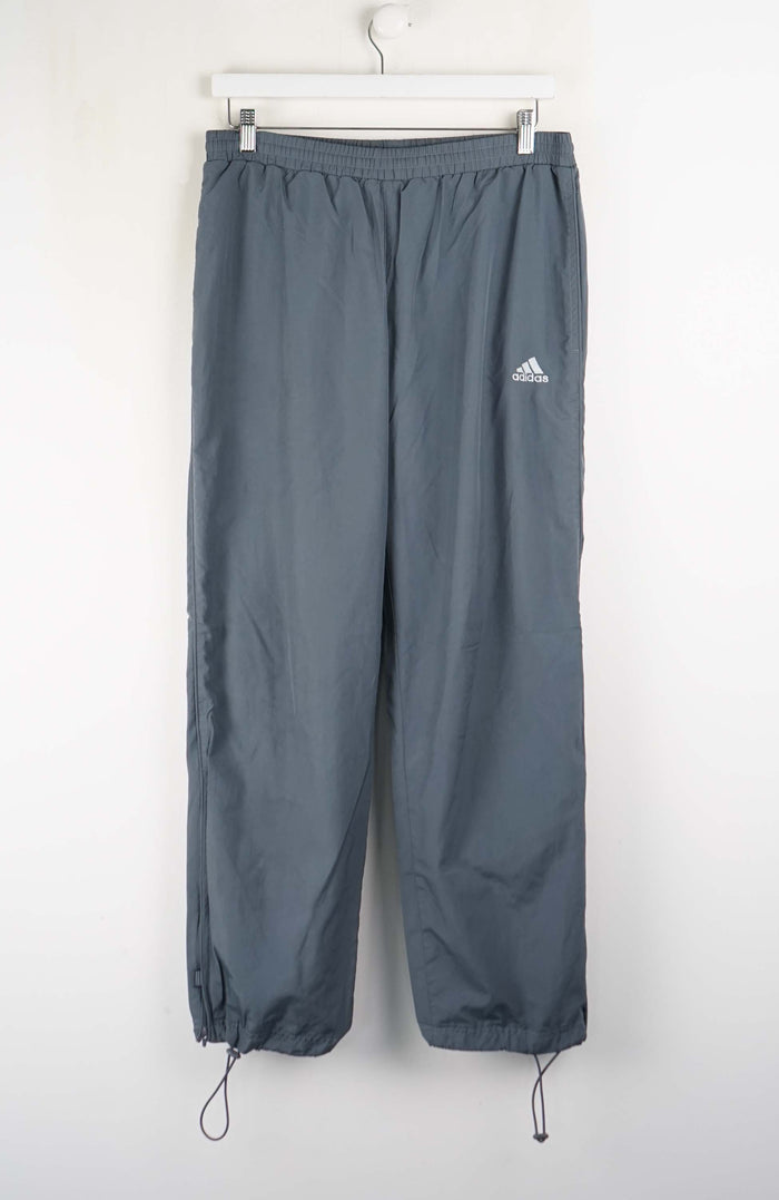 Gray Adidas pants on a white hanger against a white background
