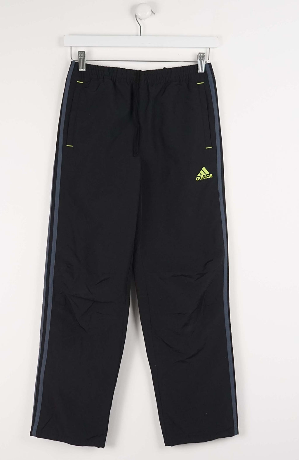 Black Adidas pants with a yellow logo on a white background