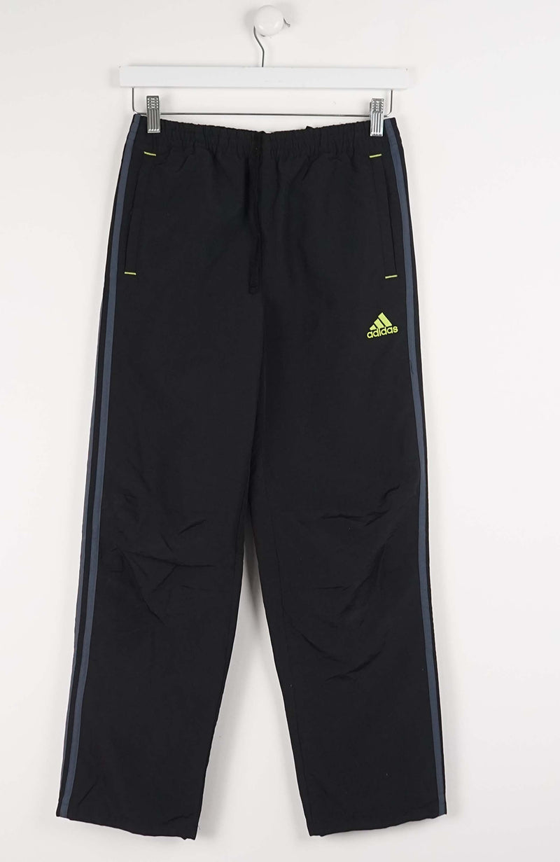 Black Adidas pants with a yellow logo on a white background