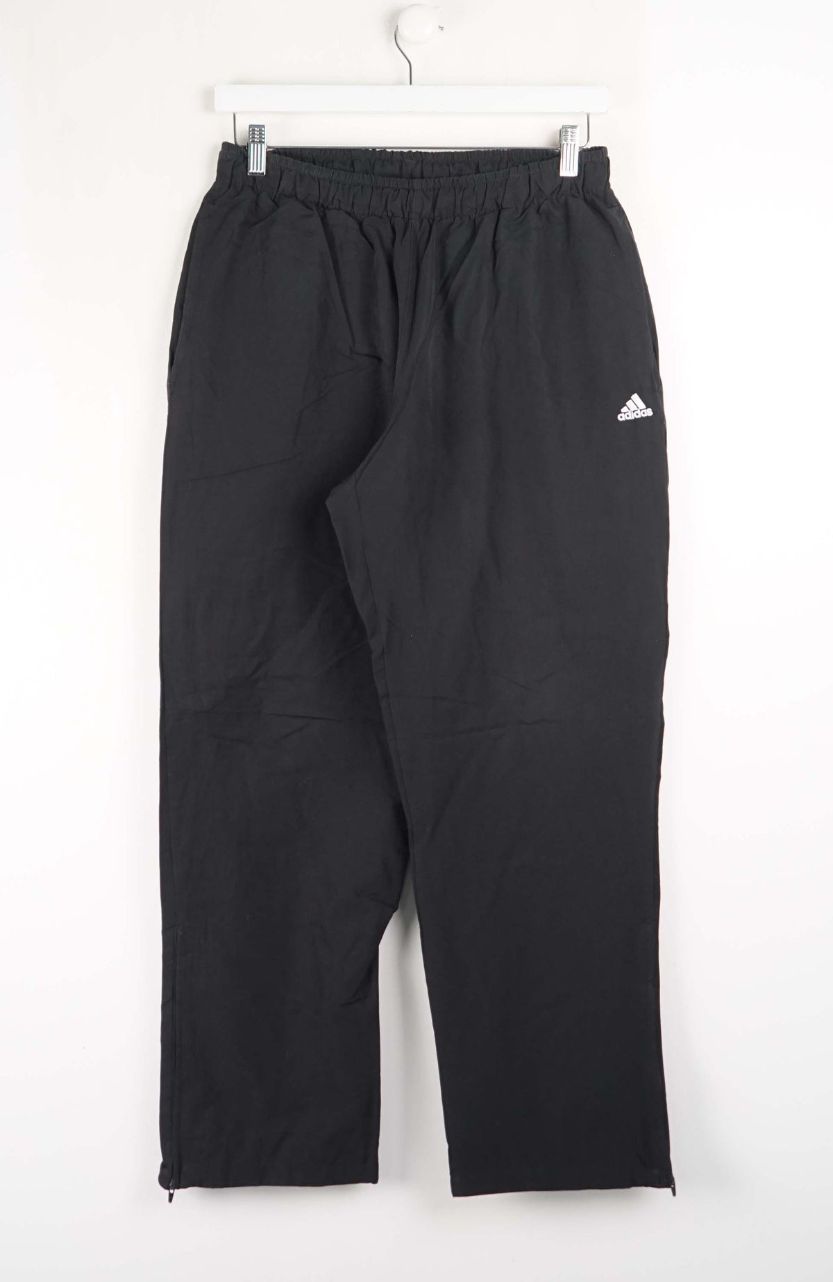 Black Adidas pants on a white background