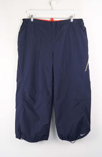 Navy blue pants with a Nike logo on a white background