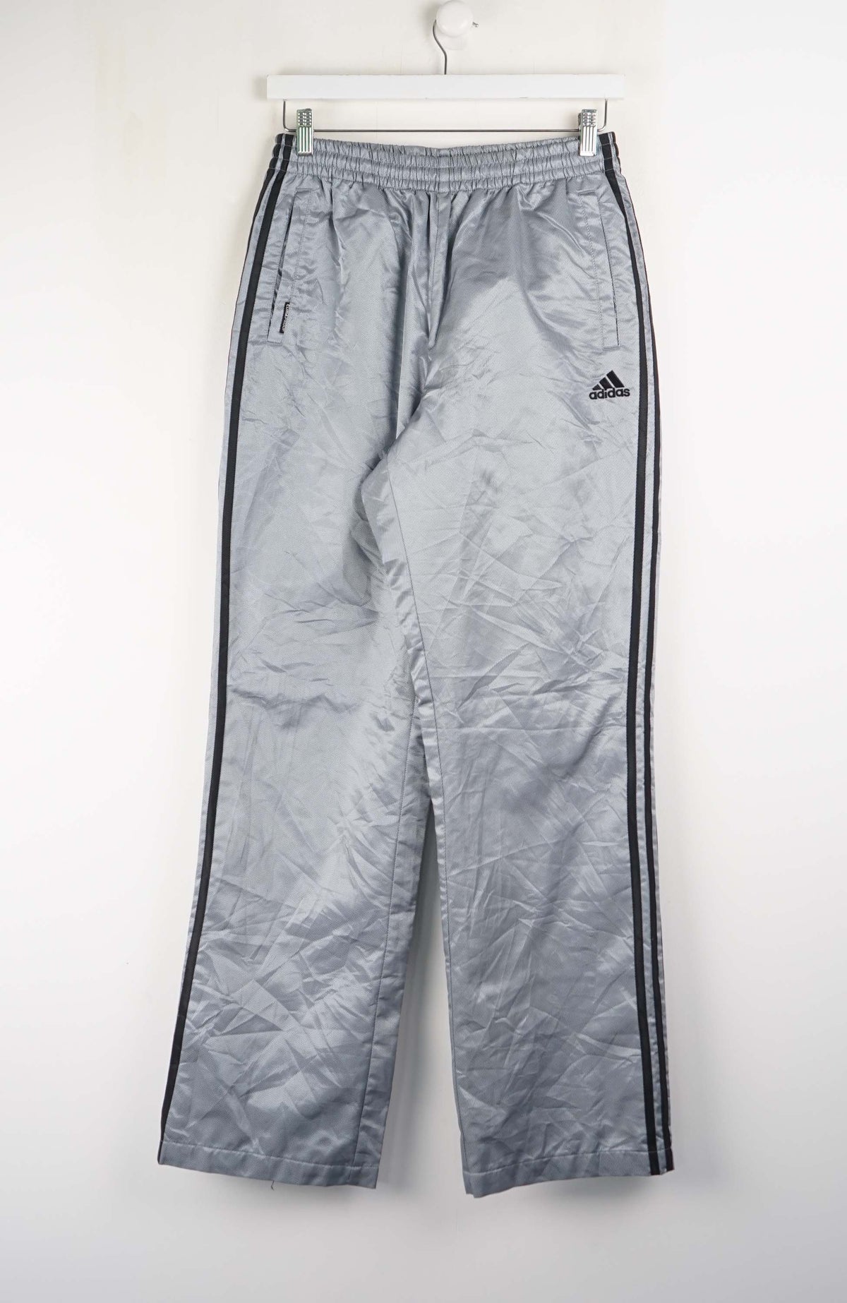 Gray Adidas tracksuit pants with black stripes on a white background