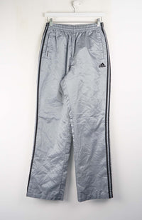 Gray Adidas tracksuit pants with black stripes on a white background