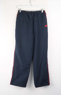 Navy blue pants with red stripes and Adidas logo on a white background