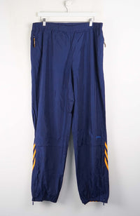 Blue pants with yellow accents hanging on a white background