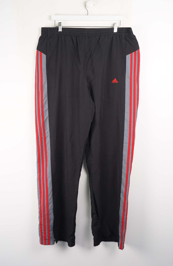 Black track pants with red and gray stripes on a white background