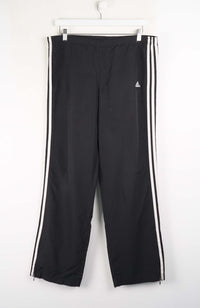 Black track pants with white stripes on a white background