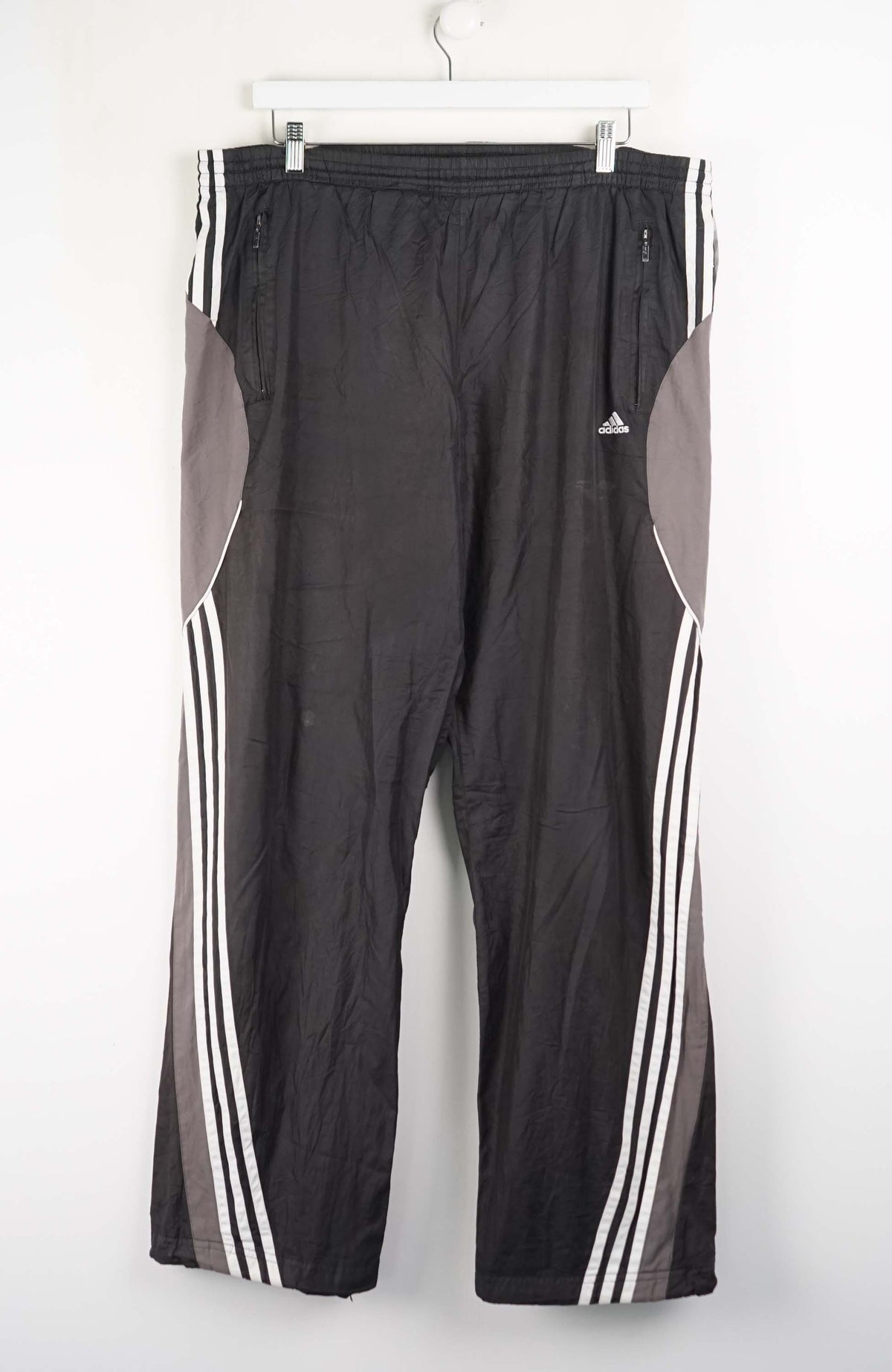 Black athletic pants with white stripes on a white background