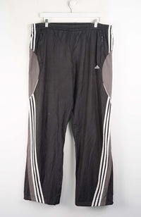 Black athletic pants with white stripes on a white background