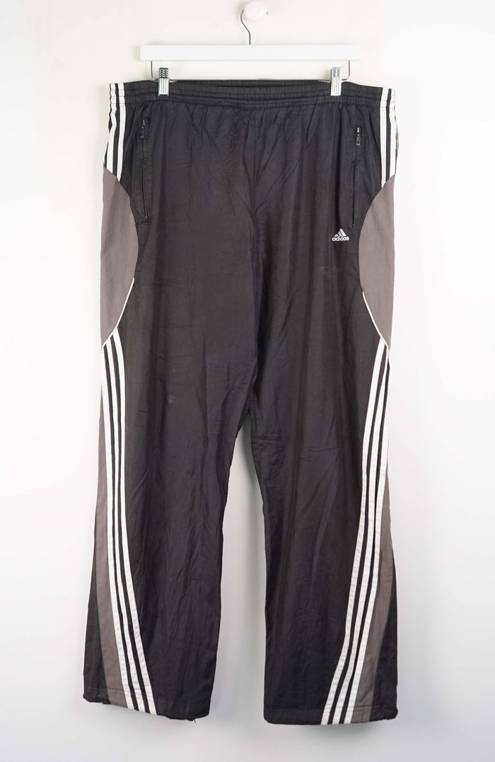 Black athletic pants with white stripes on a white background