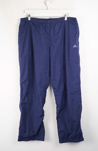 Blue Adidas pants hanging on a white background