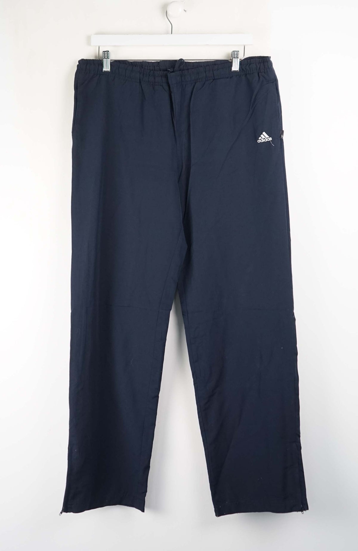 Navy blue pants with Adidas logo on a white background