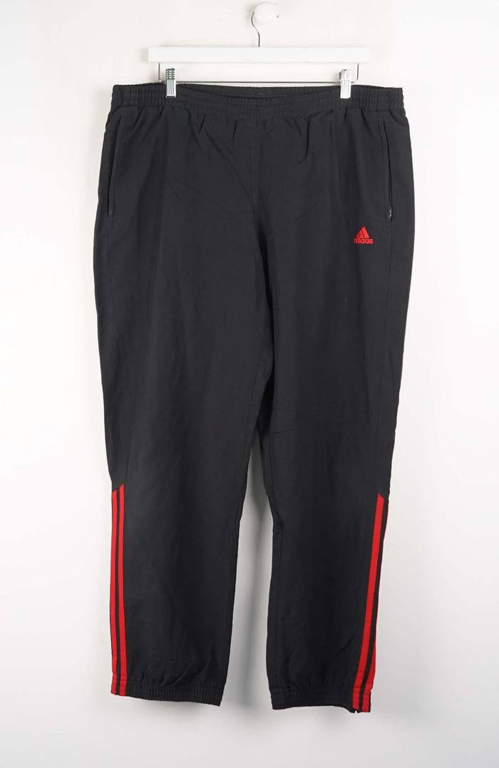 Black pants with red stripes and a triangle logo on a white background