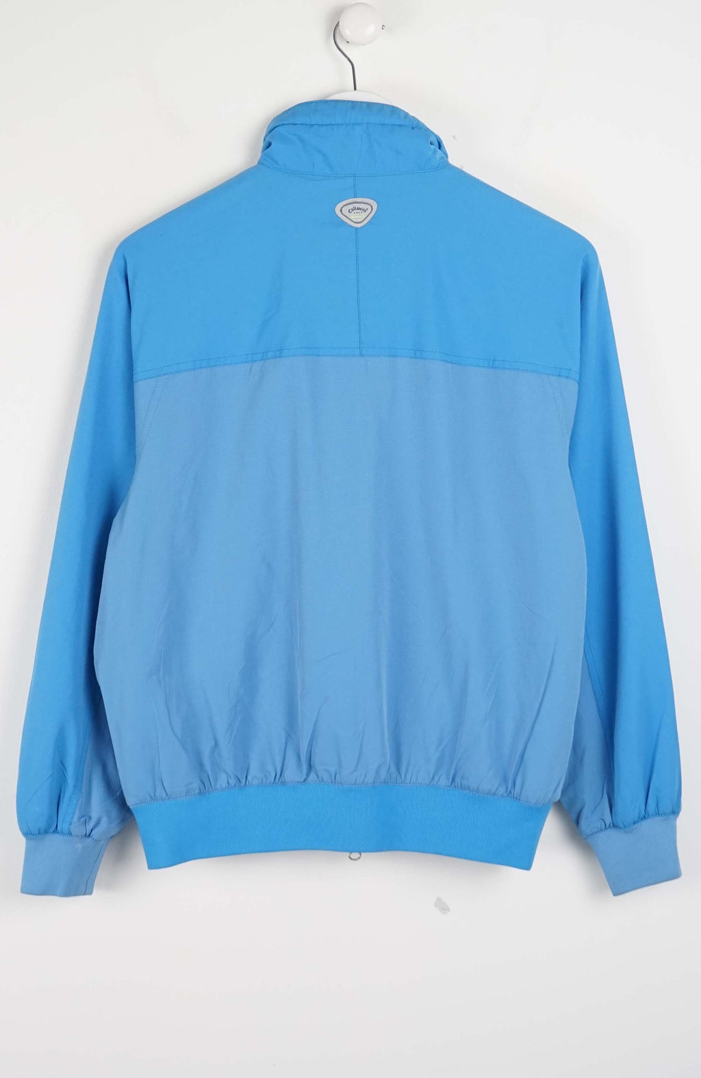 Blue jacket on a white hanger against a white background